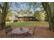 Picturesque backyard with comfortable seating area, mature trees, and lush green lawn at 5655 Mccoy Rd Nw, Acworth, GA 30101