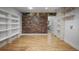 Spacious bonus room with hardwood floors, brick accent wall, and built-in shelving at 5655 Mccoy Rd Nw, Acworth, GA 30101