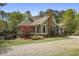 Beautiful home exterior with a stone chimney, well-maintained lawn, and a picturesque landscape at 5655 Mccoy Rd Nw, Acworth, GA 30101