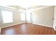 Spacious bedroom featuring hardwood floors, neutral paint, tray ceiling, and ample natural light at 11050 Skyway Dr, Duluth, GA 30097