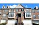 Beautiful townhome with a brick facade, multiple windows, dormers, and a two-car garage at 11050 Skyway Dr, Duluth, GA 30097