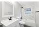 Bathroom featuring a white vanity, toilet, and shower-tub combo with marble tiling at 2457 Shiloh Dr, Decatur, GA 30034