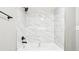 Close up of the shower-tub combo featuring marble tile and black fixtures at 2457 Shiloh Dr, Decatur, GA 30034