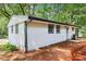 Newly renovated one-story home with a side view, surrounded by mature trees and lush greenery at 2457 Shiloh Dr, Decatur, GA 30034