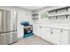 Bright kitchen featuring white cabinets, open shelves and modern stainless steel refrigerator at 2457 Shiloh Dr, Decatur, GA 30034