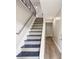 Modern staircase with gray and blue steps, white risers, and metal railing at 2457 Shiloh Dr, Decatur, GA 30034