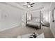 The main bedroom includes a tray ceiling, ceiling fan, four-poster bed, and ensuite bath at 3244 Lions Ruby Ln, Atlanta, GA 30349