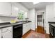 Well-lit kitchen featuring a stainless steel sink, black dishwasher, and hardwood floors at 3300 Old Mill Ct, Decatur, GA 30033