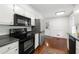 Kitchen with black appliances, white cabinetry, stainless steel fridge, and hardwood floors at 3300 Old Mill Ct, Decatur, GA 30033