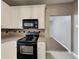 Functional kitchen featuring white cabinets, sleek black appliances, and stylish countertops at 4603 Parkway Circle, Atlanta, GA 30349