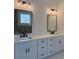 Sleek bathroom vanity with dual sinks, quartz countertop, dark hardware, and modern lighting at 6132 Hutchins Dr, Buford, GA 30518