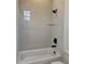 Beautiful bathroom featuring a white bathtub and shower with modern shower head and tiled walls at 6132 Hutchins Dr, Buford, GA 30518