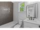 Bathroom with tiled walls and a vanity with a mirror, faucet, and sink at 6132 Hutchins Dr, Buford, GA 30518