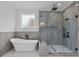 Modern bathroom featuring a soaking tub, walk-in shower, and sleek fixtures at 6132 Hutchins Dr, Buford, GA 30518