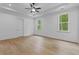Empty primary bedroom featuring hardwood flooring and two large bright windows at 6132 Hutchins Dr, Buford, GA 30518