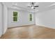 Empty primary bedroom featuring hardwood flooring and two large bright windows at 6132 Hutchins Dr, Buford, GA 30518
