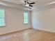 Spacious bedroom with light hardwood floors and large windows offering serene views of the outdoors at 6132 Hutchins Dr, Buford, GA 30518