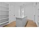 Walk-in closet featuring custom shelving with island and door to bathroom at 6132 Hutchins Dr, Buford, GA 30518