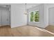 Elegant dining room with hardwood floors, stylish lighting, and a large window with tree view at 6132 Hutchins Dr, Buford, GA 30518