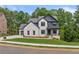 Charming two-story home with brick and siding, a manicured lawn, and mature trees at 6132 Hutchins Dr, Buford, GA 30518