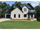Stunning two-story home features a brick facade, black accents, and a well-manicured lawn at 6132 Hutchins Dr, Buford, GA 30518