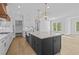 Open kitchen featuring a large island, white cabinets, granite countertops, and stainless steel appliances at 6132 Hutchins Dr, Buford, GA 30518
