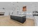 Spacious kitchen with a dark island, pendant lighting, white cabinets, and stainless steel appliances at 6132 Hutchins Dr, Buford, GA 30518