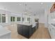 Bright, open kitchen with an island, white cabinets, stainless steel appliances, and hardwood floors at 6132 Hutchins Dr, Buford, GA 30518