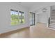 Open living area with hardwood floors, staircase, and large windows offering natural light at 6132 Hutchins Dr, Buford, GA 30518