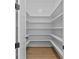 A pantry with white shelving for optimal storage and wood flooring at 6132 Hutchins Dr, Buford, GA 30518