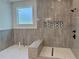 Modern tiled shower with a built-in bench, sleek fixtures, and stylish geometric accent tiles at 6132 Hutchins Dr, Buford, GA 30518