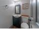 Cozy half-bathroom with dark vanity, commode, decorative sign, and wood-style flooring at 1337 Frontier Trl, Sugar Hill, GA 30518