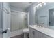 Bathroom with a modern marble vanity and shower tub with sliding glass door at 1337 Frontier Trl, Sugar Hill, GA 30518