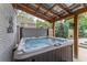 Luxurious hot tub on a covered patio, providing a relaxing spa experience in a private backyard setting at 1337 Frontier Trl, Sugar Hill, GA 30518