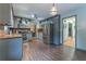 Bright eat-in kitchen with stainless steel appliances, dark wood-look flooring, and a view into the dining room at 1337 Frontier Trl, Sugar Hill, GA 30518