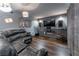 Finished basement living room with dark brown floors, wall-mounted TV, and reclining leather sofa at 1337 Frontier Trl, Sugar Hill, GA 30518
