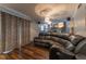 Finished basement living room with reclining leather sofa and decorative curtains at 1337 Frontier Trl, Sugar Hill, GA 30518