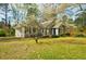 Cozy single-story house with a manicured lawn, set among blossoming trees, and featuring gray siding and dark shutters at 2867 Payton Ne Rd, Atlanta, GA 30345