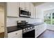 Modern kitchen with stainless steel appliances, white cabinetry, subway tile backsplash, and dark countertops at 2867 Payton Ne Rd, Atlanta, GA 30345