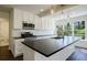 Well-lit kitchen with island sink, white cabinets, stainless appliances, and large windows overlooking the backyard at 2867 Payton Ne Rd, Atlanta, GA 30345
