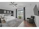 Modern bedroom with a large bed, accent wall, mounted TV, and cozy armchair at 545 Woodland Park Ter, Lawrenceville, GA 30043