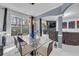 Bright dining area featuring a glass table set, modern chandelier, and views of the living room at 545 Woodland Park Ter, Lawrenceville, GA 30043