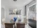 Bright dining room features a modern chandelier, glass table, and unique mirrored wall art at 545 Woodland Park Ter, Lawrenceville, GA 30043