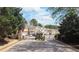 View of the gated entrance to the community with mature trees and manicured landscaping at 545 Woodland Park Ter, Lawrenceville, GA 30043