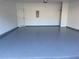 View of the spacious garage featuring an epoxy floor, clean white walls, and overhead lighting at 545 Woodland Park Ter, Lawrenceville, GA 30043