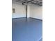 Image shows the spacious garage featuring an epoxy floor, clean white walls, and overhead lighting at 545 Woodland Park Ter, Lawrenceville, GA 30043