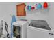 Bright laundry room with modern washer and dryer, a cabinet, shelving, and cleaning supplies at 545 Woodland Park Ter, Lawrenceville, GA 30043