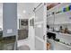 View of open pantry with white shelves stocked with food and drinks, next to living area with television at 545 Woodland Park Ter, Lawrenceville, GA 30043