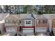 Charming townhomes with attached garages and brick and stone exteriors line a cozy neighborhood street at 545 Woodland Park Ter, Lawrenceville, GA 30043