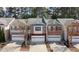 Charming townhomes with attached garages and brick and stone exteriors line a cozy neighborhood street at 545 Woodland Park Ter, Lawrenceville, GA 30043